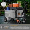 A KESSER® foldable wagon loaded with luggage and groceries, parked on a paved path with trees in the background. Produktbild-Vorschau