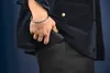 A person is putting a black wallet into their black pants pocket, while wearing a dark blue corduroy jacket. Anteprima dell’immagine prodotto