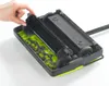 A hand is shown adjusting a part of a green and black carpet sweeper that is filled with dirt and debris. Produktbild-Vorschau