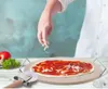 A person is sprinkling cheese on a pizza that is on a pizza stone. Podgląd zdjęcia produktu
