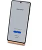 A smartphone displaying a welcome screen, resting on a wooden stand. Podgląd zdjęcia produktu