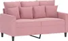 A pink velvet sofa with three back cushions and two throw pillows.