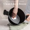 A hand is cleaning the inside of a black pot with a white cloth. Náhľad obrázku produktu