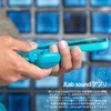 A person is holding a pair of aqua-colored earbuds in front of a blue tiled background. Anteprima dell’immagine prodotto
