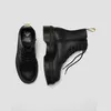 A pair of black Dr. Martens boots are shown from a top-down perspective against a plain white background. Anteprima dell’immagine prodotto