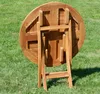 The underside of a round wooden folding table is shown on a grassy lawn. Produktbild-Vorschau