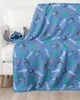 A blue blanket with a Stitch pattern is draped over a white sofa, next to a Stitch pillow. Produktbild-Vorschau