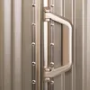 A close-up view of a suitcase handle and its attachment to the suitcase body. Podgląd zdjęcia produktu
