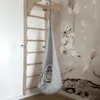 A child's room with a wooden climbing frame and a hanging pod chair. Podgląd zdjęcia produktu