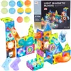 A collage of magnetic building blocks and accessories, including balls and light-up components, arranged to form a marble run. Náhľad obrázku produktu