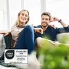 A couple sitting on a couch, smiling. Produktbild-Vorschau