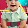 A close-up of a smiling baby wearing a light green shirt and a red safety belt, with text overlays highlighting product features. Produktbild-Vorschau