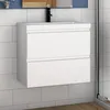 A white bathroom vanity with two drawers is mounted on a tiled wall.