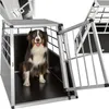 A dog is sitting inside a metal dog crate with the door open. Produktbild-Vorschau