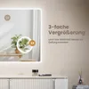 A modern bathroom vanity with a large LED mirror, showcasing a plant and makeup. Náhled obrázku produktu