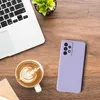 A flat lay of a laptop, a cup of coffee with latte art, and a purple phone case on a wooden desk. Produktbild-Vorschau