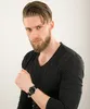 A man wearing a black long-sleeved shirt and a watch. Voir les images du produit