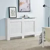A white radiator cover is shown in a room with light blue walls and a beige rug. Náhľad obrázku produktu