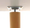 A close-up view of the underside of a table or furniture piece, showing a wooden leg attached to a metal mounting plate. Podgląd zdjęcia produktu
