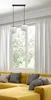 A yellow sofa with gray and beige pillows in front of a large window with white curtains. A black pendant light with two white glass globes hangs from the ceiling. Podgląd zdjęcia produktu