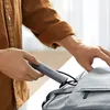 A person is placing a USB hub into a backpack. Produktbild-Vorschau