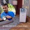 A man is using a smartphone to control a device in his home while exercising. Produktbild-Vorschau