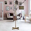 A stylish living room with a pink wall, featuring a coat rack with a hat and bags, a sofa, and a chair. Produktbild-Vorschau