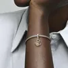Close-up of a person's arm wearing a bracelet with charms. Produktbild-Vorschau