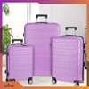 Three violet suitcases of different sizes are arranged in a studio setting. Náhled obrázku produktu