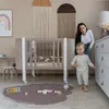 A mother and her baby in a nursery with a crib and toys. Produktbild-Vorschau