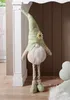 A decorative gnome with a flower on its hat stands next to a white pillar. Voir les images du produit