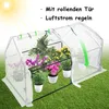 A small greenhouse filled with plants, set up on a grassy lawn. Voir les images du produit