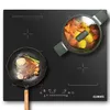 A black induction cooktop with a frying pan containing steak and vegetables on the left, and a pot with vegetables on the right. Produktbild-Vorschau