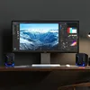 A computer setup with a large monitor displaying a landscape image, a keyboard, a mouse, and two small speakers on a wooden desk. Náhľad obrázku produktu