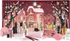 A festive makeup advent calendar with various beauty products displayed in front of a winter village scene. Produktbild-Vorschau