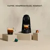 A Nespresso coffee machine with two cups of coffee and coffee capsules. Produktbild-Vorschau