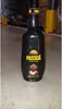 A bottle of Passoa Passion Fruit Liqueur stands on a concrete floor in what appears to be a warehouse or storage area. Produktbild-Vorschau