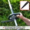 A person's hand is holding a gardening tool with an additional handle and strap, with green bushes in the background. Produktbild-Vorschau