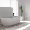 A modern bathroom with a freestanding bathtub and a tall cactus plant. Náhled obrázku produktu