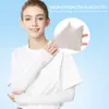 A woman wearing white arm sleeves, with a close-up inset showing the fabric's elasticity. Produktbild-Vorschau