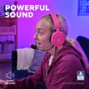 A young woman wearing pink headphones with a microphone is playing a video game. Podgląd zdjęcia produktu