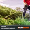 A person is using a string trimmer in a grassy area. Produktbild-Vorschau