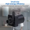A black water pump is shown in the foreground, with a blurred background of what appears to be a bathroom or kitchen. Anteprima dell’immagine prodotto