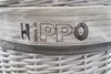 A close-up of a white wicker basket with the word "HIPPO" embroidered on a fabric band. Produktbild-Vorschau