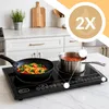 A black induction cooktop with two burners, one with a frying pan containing noodles and vegetables, and the other with a pot of red sauce, set on a marble countertop in a kitchen. Voir les images du produit