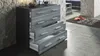 A dresser with open drawers in a room with a stone wall and tiled floor. Produktbild-Vorschau