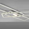 A modern, geometric LED ceiling light fixture with multiple rectangular frames, illuminated with white light, mounted on a light gray ceiling. Produktbild-Vorschau