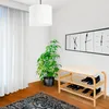 A shoe rack with a bench and shoes in a room with a plant and a clock on the wall. Produktbild-Vorschau