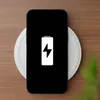 A smartphone is placed on a wireless charger on a wooden surface. Náhled obrázku produktu