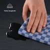 A hand is shown wiping up a spill with a checkered cloth, demonstrating absorbency. Anteprima dell’immagine prodotto